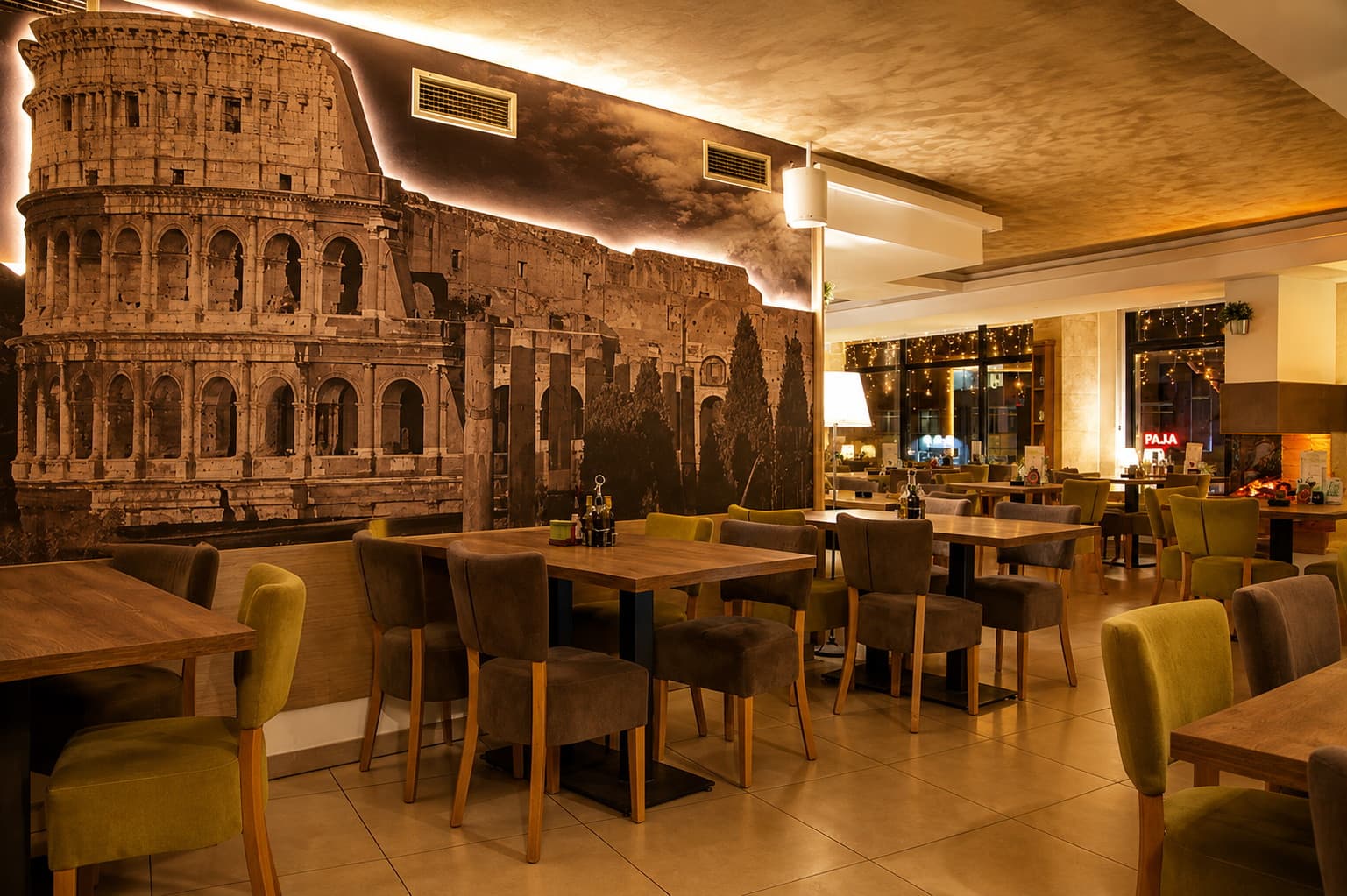 Sala restorana Sabbiadoro uveče, postavljeni stolovi u zlatnom svetlu